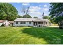 Beautifully landscaped front yard with a charming white brick home at 5428 Barnsdale Ln, Mint Hill, NC 28227
