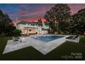 Beautiful backyard with a large pool, elegant lounge furniture, and water fountains at 5806 Bentway Dr, Charlotte, NC 28226