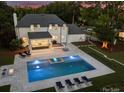 Expansive backyard with luxurious pool, lounge area, and lush landscaping at 5806 Bentway Dr, Charlotte, NC 28226
