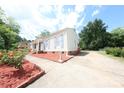 Spacious driveway leading to a charming home, enhanced by vibrant landscaping and a sunny sky at 6124 Coach Hill Ln, Charlotte, NC 28212