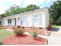 A well-maintained home with traditional siding, complemented by colorful landscaping and brick accents at 6124 Coach Hill Ln, Charlotte, NC 28212