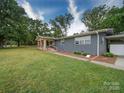 This single-story home features a charming stone porch, carport, and a well-manicured lawn at 6604 Plyler Mill Rd, Monroe, NC 28112