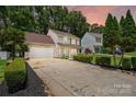 Inviting two-story home with a spacious driveway and manicured landscaping at sunset at 6640 Autumn Gate Ln, Charlotte, NC 28216