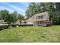 Beautiful two-story home with lush green lawn and mature trees on a sunny day at 6640 Autumn Gate Ln, Charlotte, NC 28216