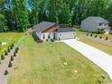 Aerial view of a home with a large front yard, modern design, and long driveway at 7728 Shalom Dr, Charlotte, NC 28216