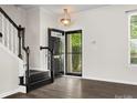 Welcoming entryway with dark wood floors, staircase, and modern lighting fixture at 8037 Lynwood Sq, Waxhaw, NC 28173