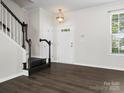 Bright entryway with dark wood floors, staircase, and window providing natural light at 8037 Lynwood Sq, Waxhaw, NC 28173