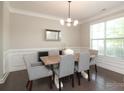 Elegant dining room featuring a modern chandelier, wainscoting, and ample natural light at 8317 Dallas Bay Rd, Charlotte, NC 28278