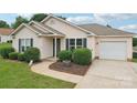Inviting single-story home with well-kept lawn, complemented by clean lines and an attached garage at 908 Dairy Meadow Ct, Monroe, NC 28110