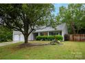 Beautiful front yard with mature tree and manicured shrubs enhance curb appeal at 9359 Hillston Ridge Rd, Huntersville, NC 28078