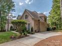 Brick home featuring an attached two-car garage and beautiful landscaping at 10924 Lederer Ave, Charlotte, NC 28277