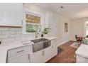 Bright kitchen featuring white cabinets, stainless steel sink, and hardwood floors at 1147 Norland Rd, Charlotte, NC 28205