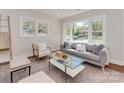 Sunlit living room with hardwood floors, neutral decor, and a large window showcasing the front yard at 1147 Norland Rd, Charlotte, NC 28205