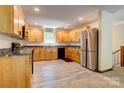 Bright kitchen featuring stainless steel refrigerator, plenty of wood cabinets, and laminate flooring at 11861 Nc Hwy 73 E Hwy, Mount Pleasant, NC 28124