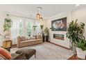Bright living room featuring a modern fireplace, large windows and indoor plants at 13022 Simoneaux Ln, Charlotte, NC 28277