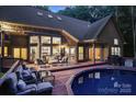 Inviting backyard with a pristine pool, spacious wooden deck, comfortable seating, and well-maintained brick exterior at 131 Sierra Woods Dr, Troutman, NC 28166