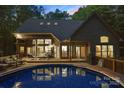 Beautiful backyard featuring a private pool, wooden deck with lounge seating, and a brick home exterior at 131 Sierra Woods Dr, Troutman, NC 28166