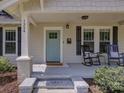 Inviting front porch with rocking chairs, offering a cozy spot to relax in front of the blue front door at 1324 E 35Th St, Charlotte, NC 28205