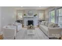 A cozy living room with a painted brick fireplace, hardwood floors, and bright, neutral furnishings at 1324 E 35Th St, Charlotte, NC 28205