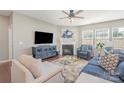 Cozy living room featuring a fireplace, ceiling fan, large TV, and comfortable seating at 15131 Oleander Dr, Charlotte, NC 28278