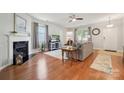 Cozy living room with hardwood floors, a fireplace, and ample natural light from the large window at 1622 Candlewood Ridge Ln, Matthews, NC 28105