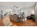 Spacious living room with hardwood floors, a ceiling fan, and open access to the dining room and kitchen at 1622 Candlewood Ridge Ln, Matthews, NC 28105