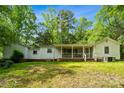 A quaint backyard featuring an enclosed porch and bordered by vibrant green grass at 1917 Tom Sadler Rd, Charlotte, NC 28214