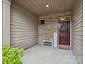 Inviting covered porch featuring brick accents and a welcome sign, adding a touch of warmth at 234 Ascot Run Way, Fort Mill, SC 29715