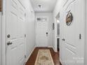 Hallway with wood floors, featuring a view of the entrance and a convenient half bathroom at 234 Ascot Run Way, Fort Mill, SC 29715