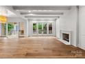 Bright living room with hardwood floors, a fireplace, and glass doors leading to an outdoor space at 2710 Briarcliff Pl, Charlotte, NC 28207