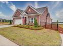 Well-manicured lawn frames this brick home with an attached two car garage and a black metal fence at 3069 Founding Fathers Dr, Gastonia, NC 28056