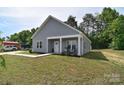 An inviting single-story house featuring gray siding, a covered porch, and a verdant, expansive lawn at 325 Cornwall Dr, Salisbury, NC 28147