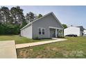 A well-maintained single-story home with a concrete walkway, front yard, and gray vinyl siding at 325 Cornwall Dr, Salisbury, NC 28147