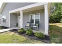 Inviting front porch area with gray siding, black mulch, and outdoor seating at 325 Cornwall Dr, Salisbury, NC 28147