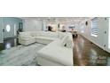 Bright and airy living room with a large white sectional sofa and hardwood flooring at 3670 9Th Street Ne Dr # 96, Hickory, NC 28601