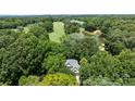 Aerial shot of a home nestled in a lush, green landscape, near a golf course and a tranquil lake at 3932 Rounding Run Rd, Charlotte, NC 28277
