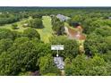 Stunning aerial view of home surrounded by lush landscaping, golf course, and pond at 3932 Rounding Run Rd, Charlotte, NC 28277