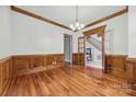 Elegant dining room featuring hardwood floors, classic wood trim, and a doorway with glass panes at 3932 Rounding Run Rd, Charlotte, NC 28277
