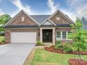 Charming single Gathering home features brick facade, manicured landscaping, and attached garage at 405 Newstyle Way, Gastonia, NC 28056