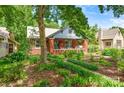 Quaint brick home with mature trees shading a landscaped yard and relaxing porch swing at 510 Wiley Ave, Salisbury, NC 28144