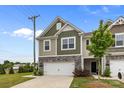 Beautiful townhome featuring a stone-accented facade, two-car garage, and a neatly kept lawn at 5207 Maynard Hill Dr, Monroe, NC 28110