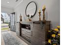 Inviting entryway with wood-look floors and a decorative console table with a round mirror and candles at 5581 Soft Shell Dr, Lancaster, SC 29720