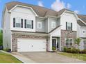Charming two-story home featuring a stone facade, black shutters, and a manicured lawn at 5581 Soft Shell Dr, Lancaster, SC 29720