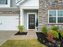 Charming home featuring a stylish front door, stone accents, and landscaped front yard at 5581 Soft Shell Dr, Lancaster, SC 29720