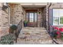 Inviting entrance with stone steps, a decorative door, and beautiful landscaping at 6010 Albiza Dr, Harrisburg, NC 28075