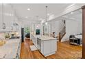 Open kitchen showcasing a large island, white cabinets, granite countertops, hardwood floors, and stainless steel appliances at 6171 Willow Farm Dr, Denver, NC 28037
