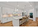 Bright kitchen featuring white cabinets, granite countertops, stainless steel appliances, and hardwood floors at 6171 Willow Farm Dr, Denver, NC 28037