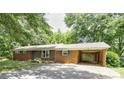 Charming brick ranch home featuring a carport, mature trees and nicely landscaped front yard at 619 E Sanders Rd, Shelby, NC 28150