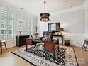 Bright office space with large desk, plantation shutters, statement lighting, and light hardwood floors at 6309 Wakehurst Rd, Charlotte, NC 28226