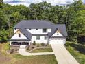 An aerial view showcasing a modern farmhouse with a large lot surrounded by lush trees at 685 Knollcrest Ne Dr, Concord, NC 28025